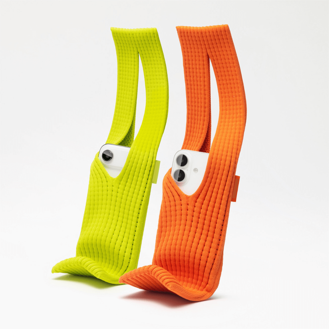 Neon yellow and orange elastic iPhone pocket straps holding a smartphone, premium hands-free mobile carry accessory.